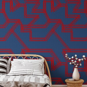May include: A bed with a white and black striped comforter and a gray throw blanket. The headboard is made of natural woven wicker. The wall behind the bed is painted a deep blue and features a red geometric pattern.
