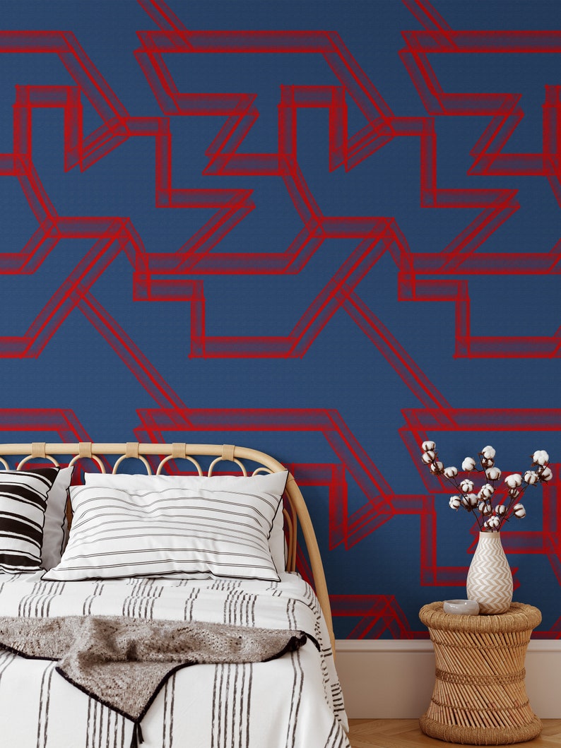 May include: A bed with a white and black striped comforter and a gray throw blanket. The headboard is made of natural woven wicker. The wall behind the bed is painted a deep blue and features a red geometric pattern.
