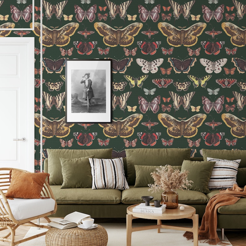 K&ouml;nnte beinhalten: Ein gr&uuml;nes Wohnzimmer mit einer Couch und einem Couchtisch. Die W&auml;nde sind mit einer Tapete mit einem Schmetterlingsmuster bedeckt. &Uuml;ber der Couch h&auml;ngt ein gerahmtes Bild an der Wand.