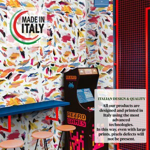 May include: A retro arcade game with a colorful abstract pattern wallpaper in the background. The arcade game has a sign that says "Retro Games". The text "Made in Italy" is visible on the wall.