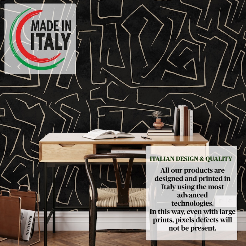 May include: Black and white abstract geometric pattern wallpaper with gold lines. The wallpaper is behind a wooden desk with a chair and books. The text "MADE IN ITALY" is in a red, white, and green circle in the upper left corner of the image. The text "ITALIAN DESIGN & QUALITY" is in the lower right corner of the image. The text below reads "All our products are designed and printed in Italy using the most advanced technologies. In this way, even with large prints, pixels defects will not be present."