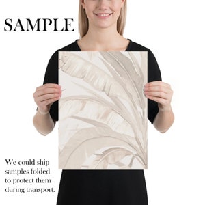 Pu&ograve; includere: Una stampa digitale con un'illustrazione in stile acquerello di foglie di banana beige su sfondo bianco. La stampa &egrave; tenuta da una persona.