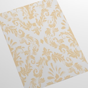 K&ouml;nnte beinhalten: Ein wei&szlig;er Hintergrund mit einem sich wiederholenden Muster aus goldenen floralen Designs. Das Design ist ein traditionelles Damastmuster.