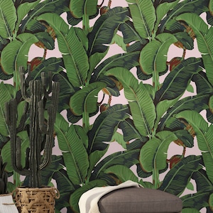 May include: A pink background with a repeating pattern of large green banana leaves. The leaves are dark green with a lighter green vein pattern.