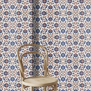 May include: A white chair with a wooden frame and a woven seat sits in front of a wall covered in blue, red, and green patterned tiles.