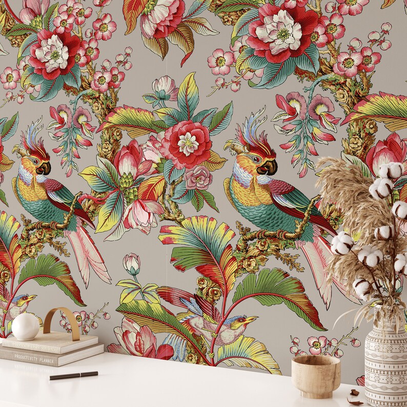Puede incluir: Un dise&ntilde;o de papel tapiz con un patr&oacute;n floral tropical con loros y hojas de palma. El fondo es gris claro con colores vibrantes de rojo, rosa, verde, amarillo y azul.