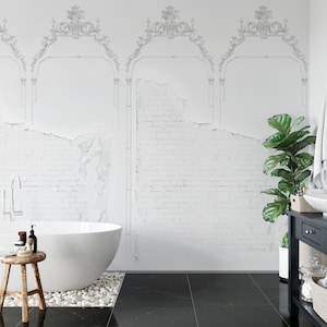 May include: A white freestanding bathtub with a white tiled wall behind it. The wall has a distressed brick pattern and a decorative molding design. A black tiled floor is in the foreground. A green plant is in a white pot on the right side of the image.