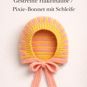 May include: A handmade, striped crochet bonnet in yellow and pink, with a matching bow. The bonnet features the text "Häkelanleitung Gestreifte Häkelhaube / Pixie-Bonnet mit Schleife". This item is a charming, handcrafted accessory.