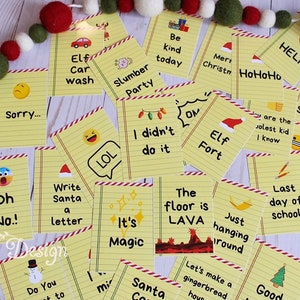 Op de afbeelding: Een verzameling gele papieren notities met verschillende kerstthema's en emoji's. De notities zijn versierd met rood-witte gestreepte randen. Een slinger van rode, groene en witte vilten ballen en andere kerstversieringen staan op de achtergrond.