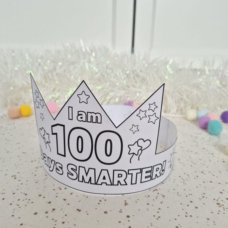 May include: A white paper crown with the text "I am 100 days SMARTER!" in black. The crown has star and heart decorations. Perfect for a child's 100th day of school celebration.