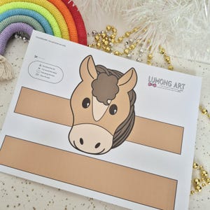 Pu&ograve; includere: Un lavoretto stampabile a forma di testa di cavallo su carta bianca con dettagli marroni e beige. La carta include le istruzioni e il testo "LUMONG ART". Un macram&egrave; arcobaleno e perline dorate sono sullo sfondo.