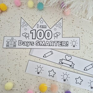 May include: A black and white paper crown with the text "I am 100 Days SMARTER!" and decorative elements like stars, hearts, and lightbulbs. Includes additional strips with pencils, hearts, and lightbulbs. Perfect for a school celebration.