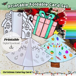 May include: Printable Christmas card set featuring foldable designs. The image displays a gingerbread house, a gift box, and Christmas trees, partially coloured in green, pink, and blue. Text includes "Printable Foldable Card Set" and "Christmas Coloring Card".