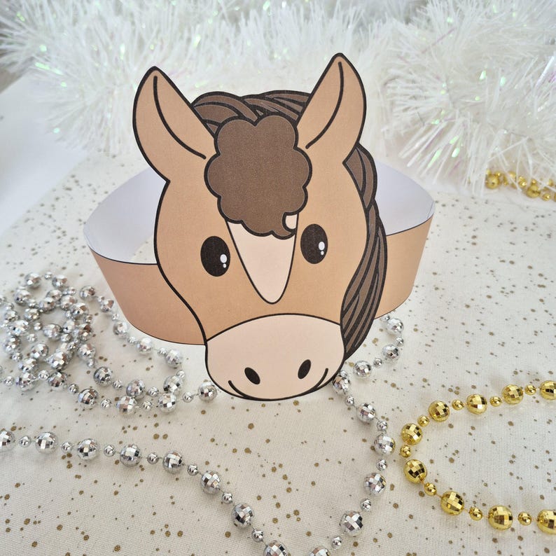Pu&ograve; includere: Una corona di cavallo di carta con un viso marrone chiaro, una criniera marrone scuro e una fascia bianca. Il cavallo ha grandi occhi neri e un muso marrone chiaro. Sullo sfondo ci sono perline decorative argentate e dorate.