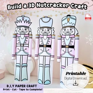 Puede incluir: Tres cascanueces de papel en rosa pastel, azul y blanco, con detalles dorados. La imagen incluye el texto "Build a 3D Nutcracker Craft" y "D.I.Y PAPER CRAFT Print Cut Tape to Complete!" Hay una descarga digital disponible.
