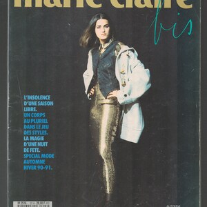 May include: A magazine cover featuring a woman wearing a white coat over a gold sequined top and black vest. The magazine is titled "marie claire bis" and the text on the cover reads "L'insolence d'une saison libre. Un corps au pluriel dans le jeu des styles. La magie d'une nuit de fete. Special mode automne hiver 90-91."