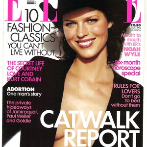 May include: A magazine cover featuring a woman wearing a black hat and a black top. The magazine is titled "ELLE" and the cover story is "10 Fashion Classics You Can't Live Without".