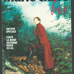 May include: A magazine cover for Marie Claire featuring a woman wearing a red coat and a plaid skirt standing in a forest. The cover text reads "Edition Speciale Toute La Mode Automne Hiver 93-94".