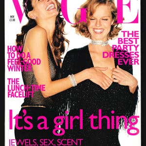 May include: Vogue magazine cover featuring two women laughing. The cover text reads "It's a girl thing" and "The Best Party Dresses Ever".