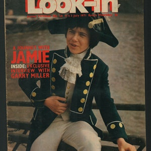 Puede incluir: Una portada de revista con un joven que lleva una chaqueta azul y dorada y un cuello de encaje blanco. La revista se titula "Look-in" y el texto de la portada dice "A Journey with Jamie" y "Inside: Exclusive Interview with Garry Miller".