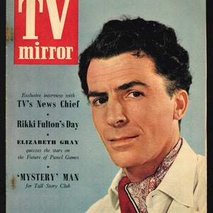 May include: A magazine cover featuring a man in a white shirt with a red and white patterned scarf. The magazine is titled "TV mirror" and features the text "Exclusive interview with TV's News Chief" and "Rikki Fulton's Day".