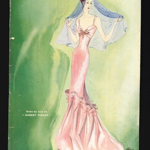 May include: Vintage magazine cover featuring a fashion illustration. The cover shows a woman in a pink evening gown with a bow detail and a flowing veil. The magazine title "Modes & Travaux" is at the top, with text in French.