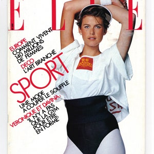 Könnte beinhalten: Ein Magazincover mit einer Frau, die ein weißes Shirt mit dem Text "80-BD CAMINSKY" trägt, schwarze Shorts und weiße Leggings. Das Magazin heißt "ELLE" und der Titel der Titelgeschichte lautet "SPORT: UNE MODE A COUPER LE SOUFFLE VERONIQUE ET DAVINA: 'IL N'Y A PAS QUE LA GYM POUR ETRE EN FORME."