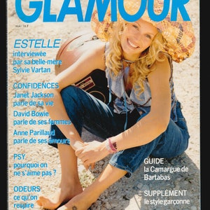 Op de afbeelding: Een tijdschriftcover met een vrouw die een strohoed en een blauwe spijkerbroek draagt. Het tijdschrift heet "Glamour" en bevat artikelen over Janet Jackson, David Bowie en Anne Parillaud. De cover bevat ook een gids voor de Camargue-regio in Frankrijk.
