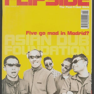 May include: A yellow magazine cover with the title "FLIPSIDE" in red letters. The cover features a photo of five men in front of a yellow background. The text "Five go mad in Madrid? ASIAN DUB FOUNDATION" is printed in white letters on the cover.