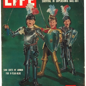 Può includere: Una copertina della rivista LIFE del 19 dicembre 1955, che mostra tre giovani ragazzi vestiti con armature complete, che tengono spade e scudi. Il titolo della copertina recita "$ 100 di armature per bambini di 6 anni".