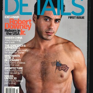 May include: A magazine cover featuring Robert Downey Jr. with the title "DETAILS" and the text "First Issue". The cover features a photo of Robert Downey Jr. with a tattoo of the American flag on his chest.