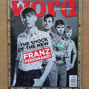 Puede incluir: Una portada de revista con la banda Franz Ferdinand. La palabra "WORD" está en letras rojas grandes en la parte superior. La portada incluye el texto "THE SHOCK OF THE NEW" y "MUSIC AND MORE". La revista está fechada el 15 de mayo de 2004.