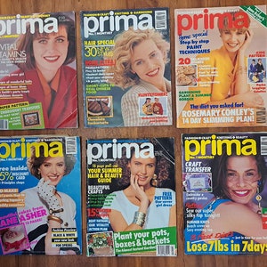 Op de afbeelding: Een stapel van acht Prima-tijdschriften met verschillende knutsel- en interieurprojecten. De omslagen tonen kleurrijke ontwerpen en titels zoals "Haar Special 30 Nieuwe Stijlen", "Huis Extra!", "Stap voor Stap Verftechnieken", "Gratis Binnenin 15% Kortingkaart", "Uw Zomer Haar- en Beautygids", "Knutseltransfer" en "Verlies 7 kg in 7 Dagen".