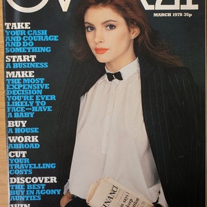 Pode incluir: Uma capa de revista com uma mulher vestindo uma camisa branca com uma gravata borboleta preta e um blazer preto de riscas. A revista chama-se "OVER21" e o texto da capa diz: "Pegue seu dinheiro e sua coragem e faça algo. Comece um negócio. Tome a decisão mais cara que você já tomará: ter um bebê. Compre uma casa. Trabalhe no exterior. Reduza seus custos de viagem. Descubra a melhor compra nas tias em apuros. Ganhe um vestido de seda pura Gina Fratini no valor de £ 250."