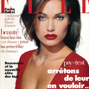 Könnte beinhalten: Ein Magazincover mit einer Frau mit dunklen Haaren und roten Lippen. Das Magazin heißt "ELLE" und die Titelgeschichte handelt von Isabella Rossellini. Der Text auf dem Cover erwähnt auch Carla Bruni und einen Beauty-Trend.