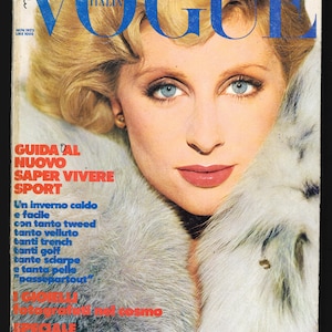 May include: A vintage Vogue Italia magazine cover featuring a woman with blonde hair wearing a white fur collar. The cover text reads "GUIDA AL NUOVO SAPER VIVERE SPORT" and "NOV. 1973 LIRE 1000".