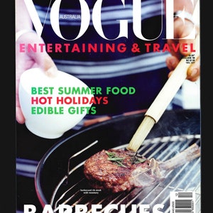 May include: A magazine cover for Vogue Australia featuring a close-up of a grilled steak with rosemary on a barbecue grill. The cover text reads "ENTERTAINING & TRAVEL", "BEST SUMMER FOOD", "HOT HOLIDAYS", "EDIBLE GIFTS", and "BARBECUES".