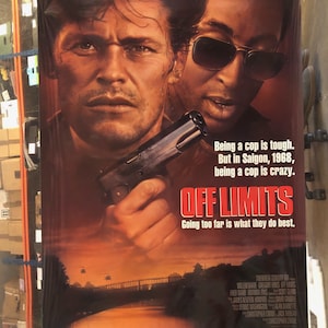 Puede incluir: Un póster de película para la película "Fuera de límites" protagonizada por Willem Dafoe y Gregory Hines. El póster presenta un primer plano de los dos actores, con Dafoe sosteniendo un arma. El lema del póster es "Ser policía es duro. Pero en Saigón, 1968, ser policía es una locura. Ir demasiado lejos es lo que mejor hacen."