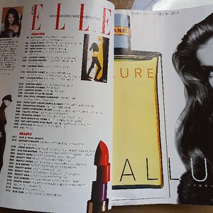 May include: A magazine spread featuring a black and white photo of a woman with long hair and a close-up of a bottle of perfume with the word "ALLURE" printed on the label. The magazine is titled "ELLE" and features a list of fashion and beauty articles.