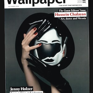 Pode incluir: Uma capa de revista com uma máscara preta e branca com esmalte de unha vermelho nas mãos que a seguram. A revista é intitulada "Wallpaper*" e o editor convidado é Hussein Chalayan. O texto "Arte, dança e Nicósia" também está na capa.