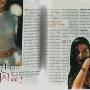 May include: A magazine spread featuring two women. The woman on the left is wearing a white sheer top and white underwear. The woman on the right is wearing a black tank top and has long dark hair. The magazine spread features Korean text.