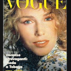 Puede incluir: Portada de la revista Vogue Italia, mayo de 1986, con una mujer rubia de ojos azules. El título de la revista está en letras amarillas. El texto incluye "vacanze stravaganti: moda a Tobago" y "SEXY DUEPEZZI DA CITTÀ."
