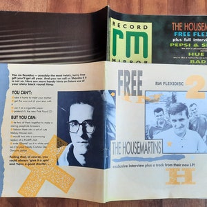 Könnte beinhalten: Ein Magazincover mit einem Foto der Band The Housemartins, mit dem Text "FREE FLEXIDISC" und "exclusive interview plus a track from their new LP!" Das Magazin heißt "Record Mirror".