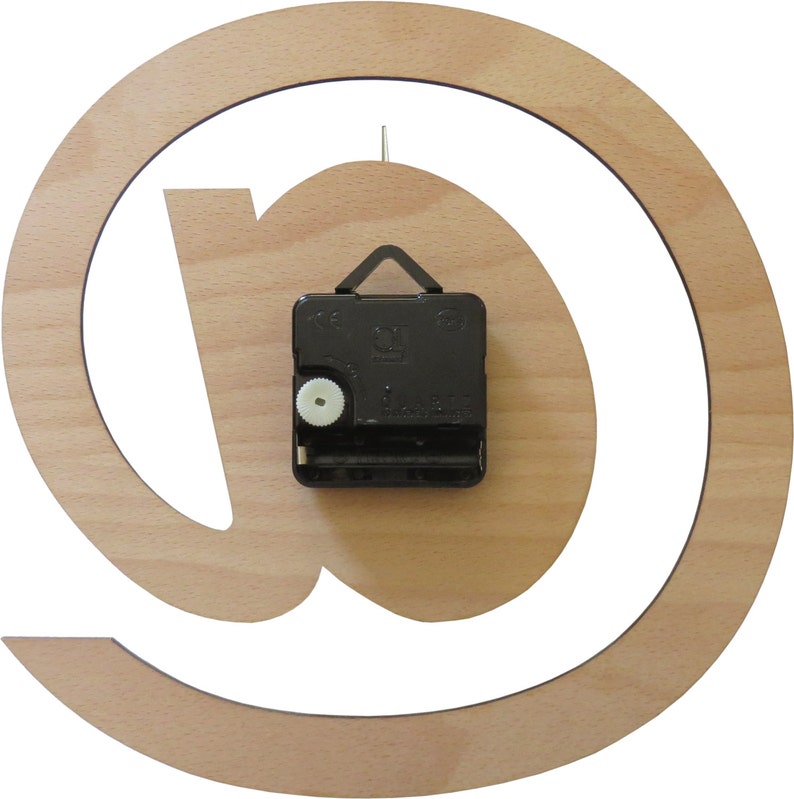 May include: A wooden clock with an @ symbol design. The clock is made of light wood and has a black clock mechanism on the back.