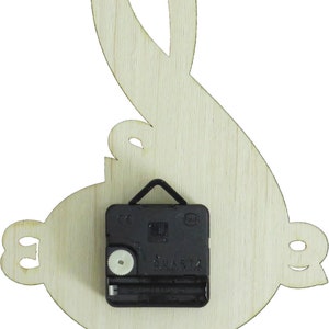 May include: A wooden wall clock shaped like a treble clef. The clock has a black quartz movement with a white dial.