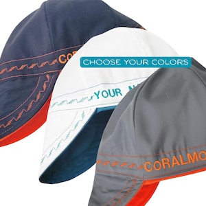 Puede incluir: Tres gorras de soldador en azul marino, blanco y gris. Cada gorra presenta una parte inferior de la visera en contraste y costuras decorativas en zigzag. Las gorras azul marino y gris tienen bordados naranjas, la blanca lleva el texto CHOOSE YOUR COLORS y YOUR NAME.