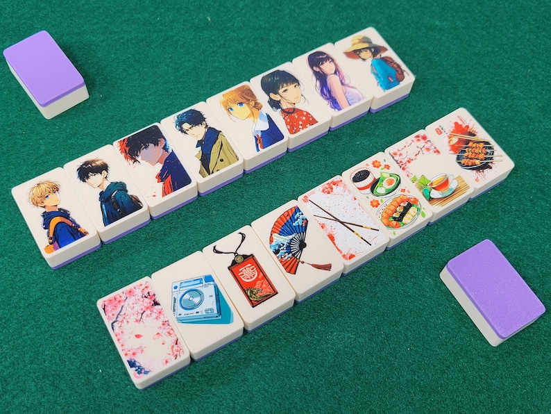 May include: A set of double-sided dominoes with colorful illustrations. One side features anime characters and the other side features Japanese-themed designs like cherry blossoms, fans, and chopsticks.