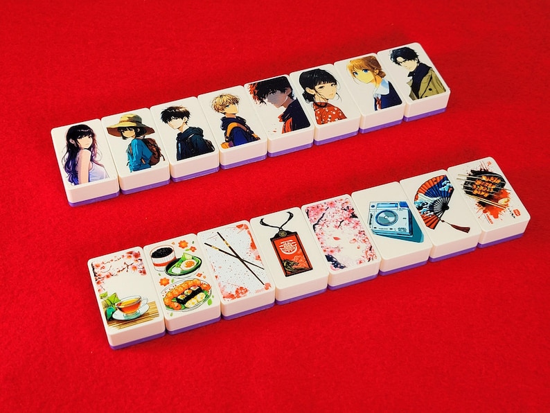 May include: A set of 14 white rectangular tiles with colorful images. The tiles feature anime characters, flowers, food, and other designs. The tiles are arranged in two rows on a red surface.