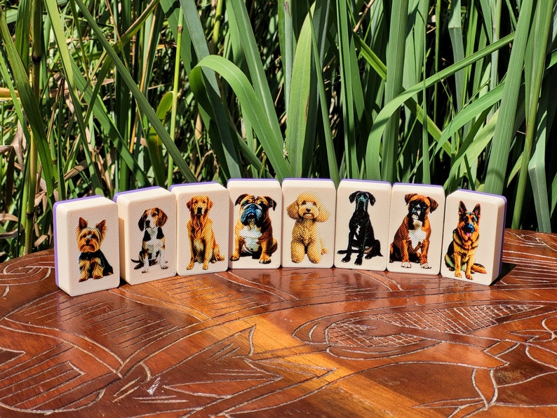 May include: Nine colorful dominoes with images of different dog breeds. Each domino features a different dog breed, including a Yorkshire Terrier, Beagle, Golden Retriever, Bulldog, Poodle, Black Labrador Retriever, Boxer, German Shepherd, and a Dachshund.