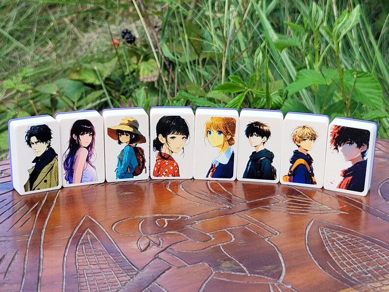 May include: Eight white rectangular tiles with blue edges, each featuring a different anime character illustration. The tiles are arranged in a row on a wooden surface.